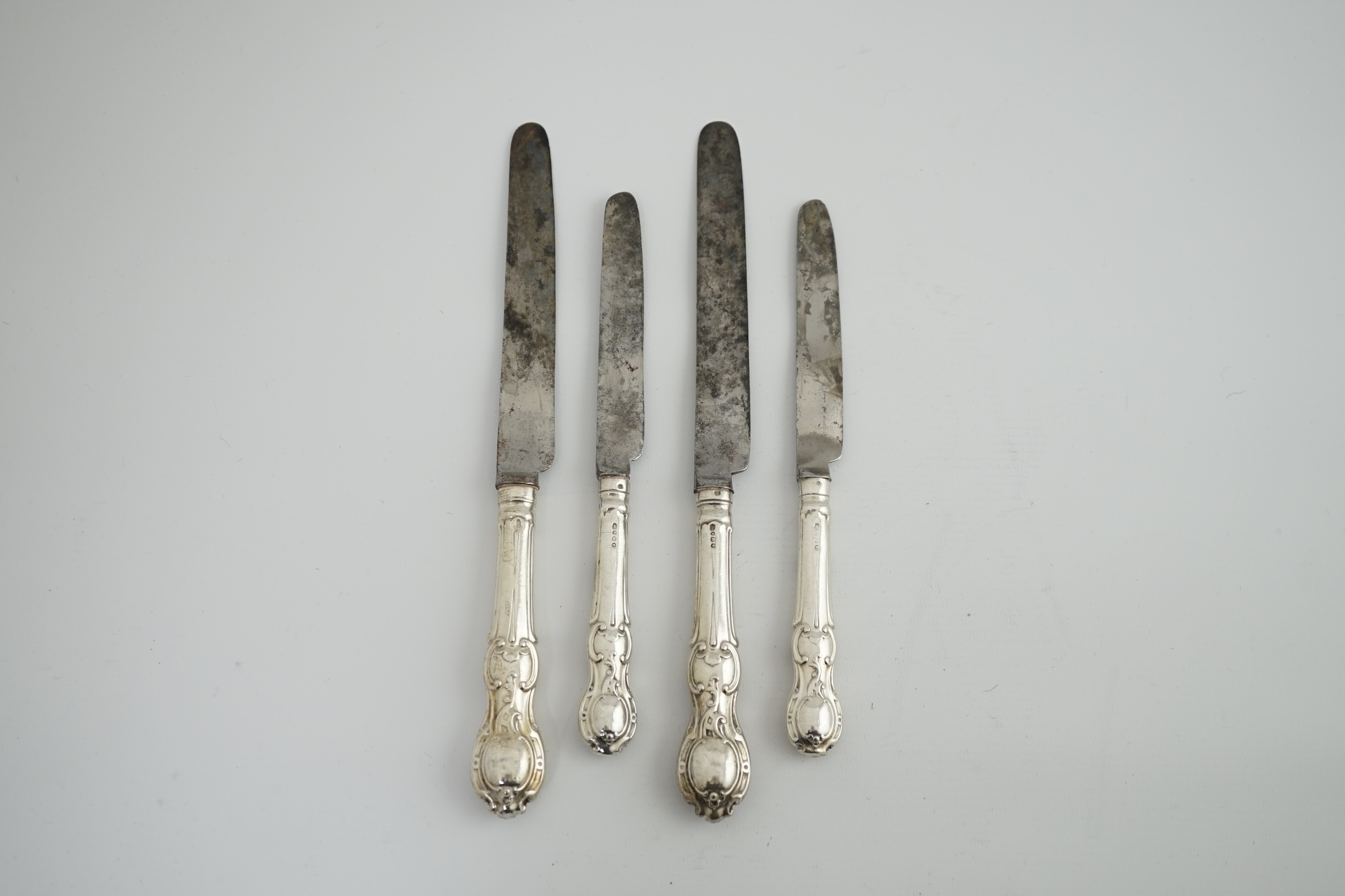 A matched set of nine Victorian silver rococo handled table knives, with steel blades, and eight matched Victorian silver rococo handled dessert knives.